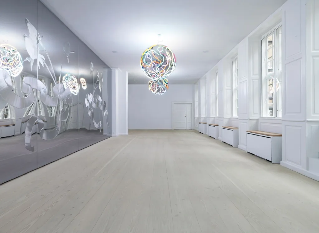 Sala diáfana con suelo Dinesen Douglas claro y lámparas de cristal