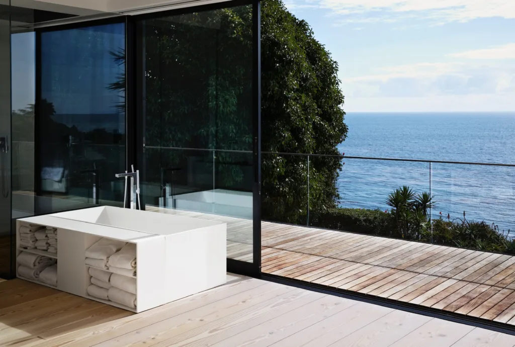 Baño con bañera exenta y suelo de madera Dinesen frente al mar