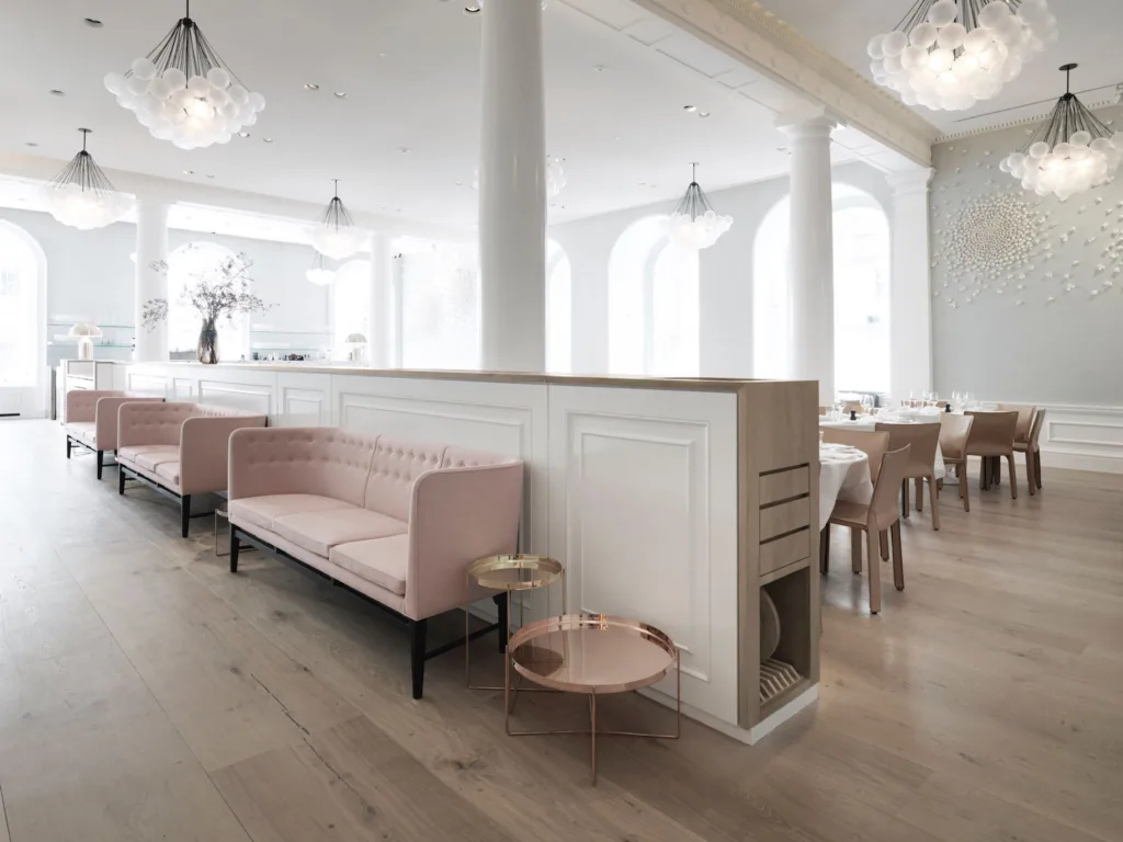 Restaurante con suelo Dinesen Douglas y sofás rosa