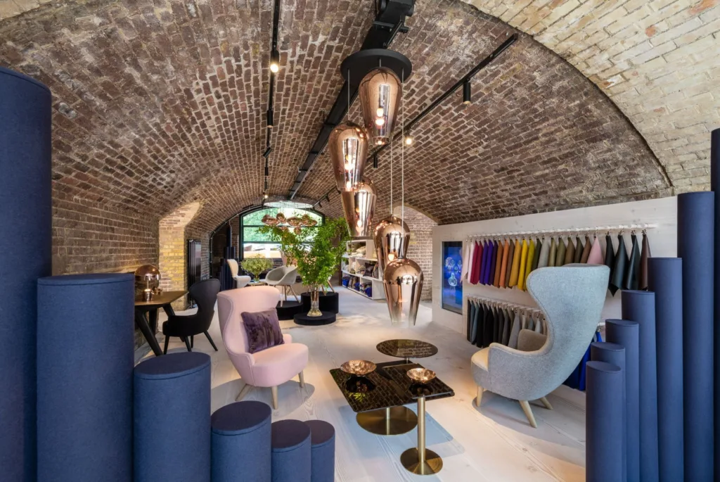 Showroom bajo bóveda de ladrillo con muestras de tejidos y suelo Dinesen