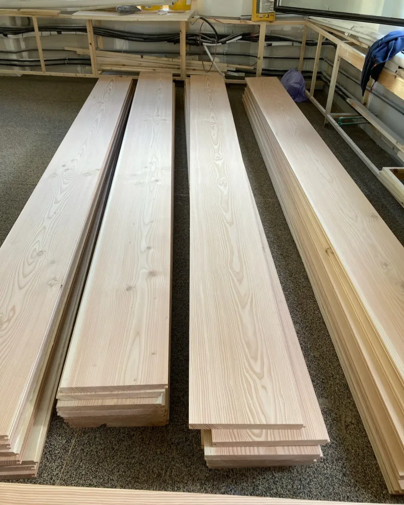 Tablas Douglas apiladas en una estancia de la obra para aclimatar antes de la instalación
