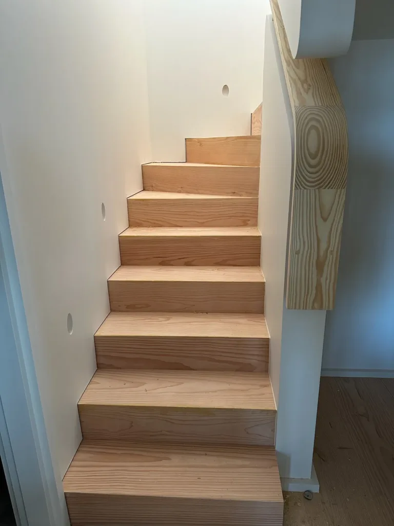 Arranque de una escalera recta con huellas y tabicas de madera