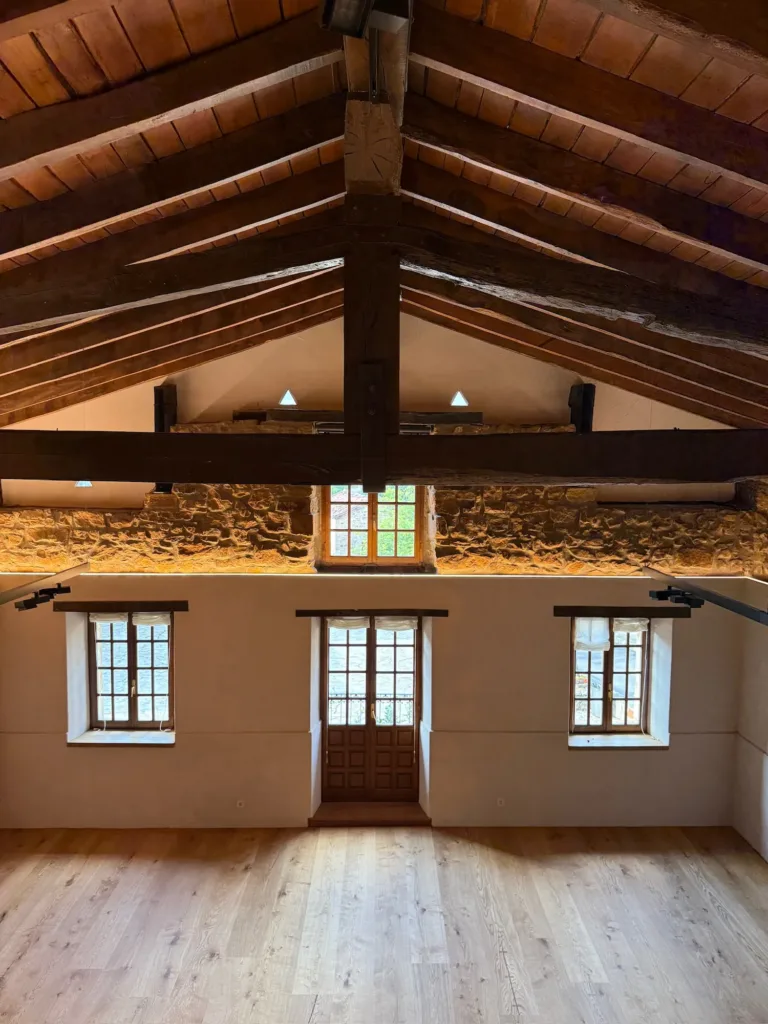 Sala superior del Asador Etxebarri (Axpe) con suelo Dinesen Layers HeartOak, muros de piedra y cubierta de madera