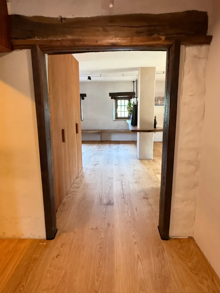 Paso con dintel de madera antigua y suelo Dinesen Layers HeartOak en el Asador Etxebarri