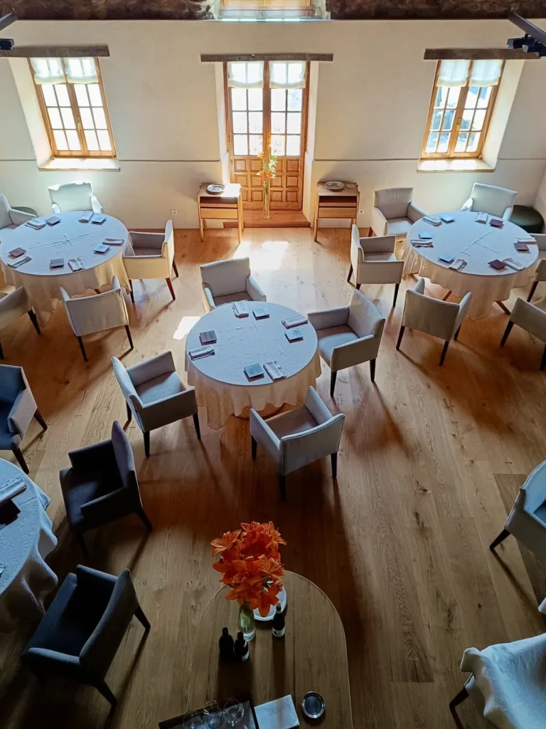 Comedor del Asador Etxebarri en servicio, visto desde la planta superior: mesas redondas sobre suelo Dinesen Layers HeartOak