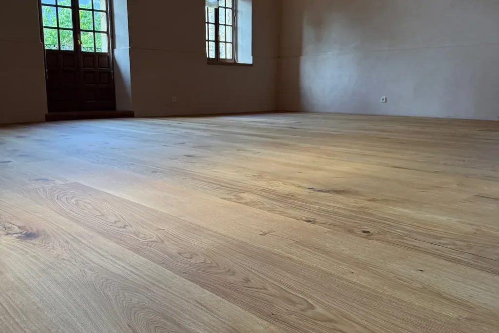 Sala del Asador Etxebarri con muro de piedra y ventanas, suelo Dinesen Layers HeartOak de 300 mm