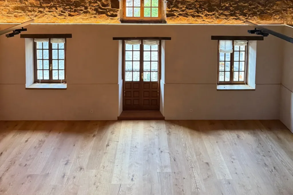 Sala superior del Asador Etxebarri (Axpe) con suelo Dinesen Layers HeartOak, muros de piedra y ventanas