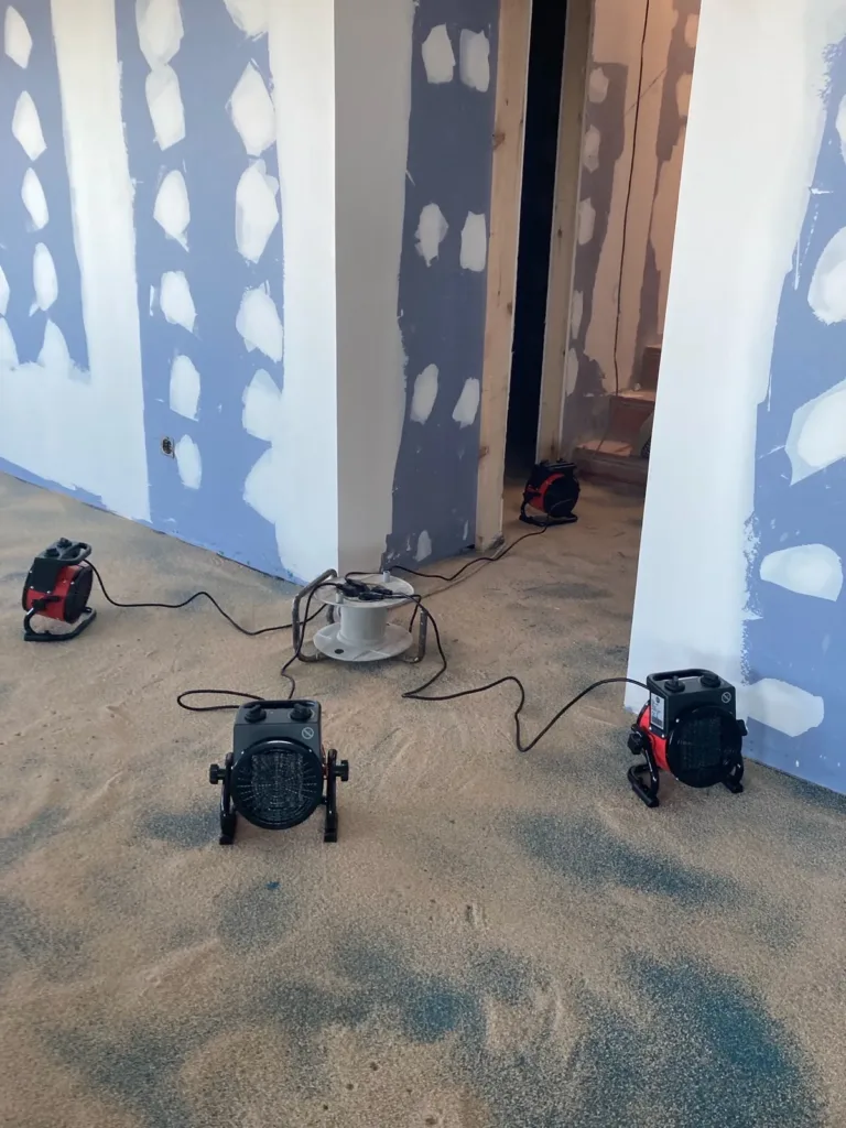 Cuatro calefactores eléctricos sobre una solera imprimada con arena