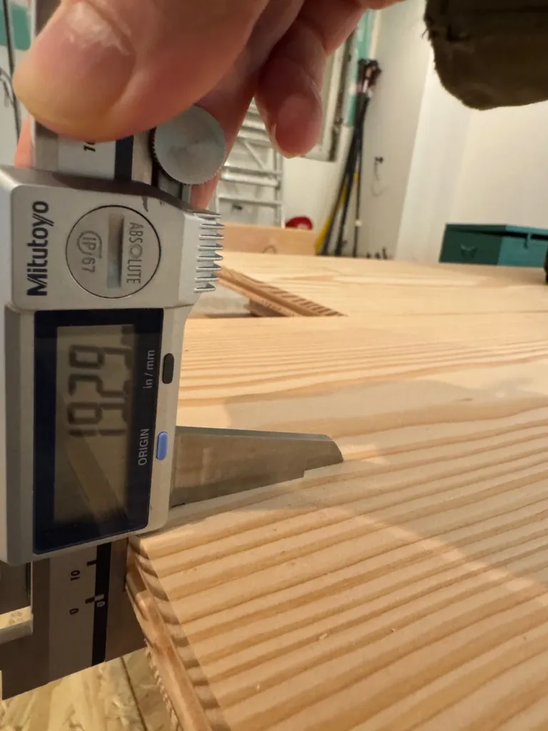 Calibre digital midiendo el canto de una tabla de Douglas; la pantalla marca 19.29