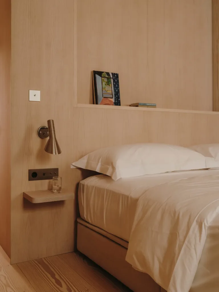 Dormitorio de Casa Ambrose con cabecero de madera y suelo Dinesen Layers Douglas Classic