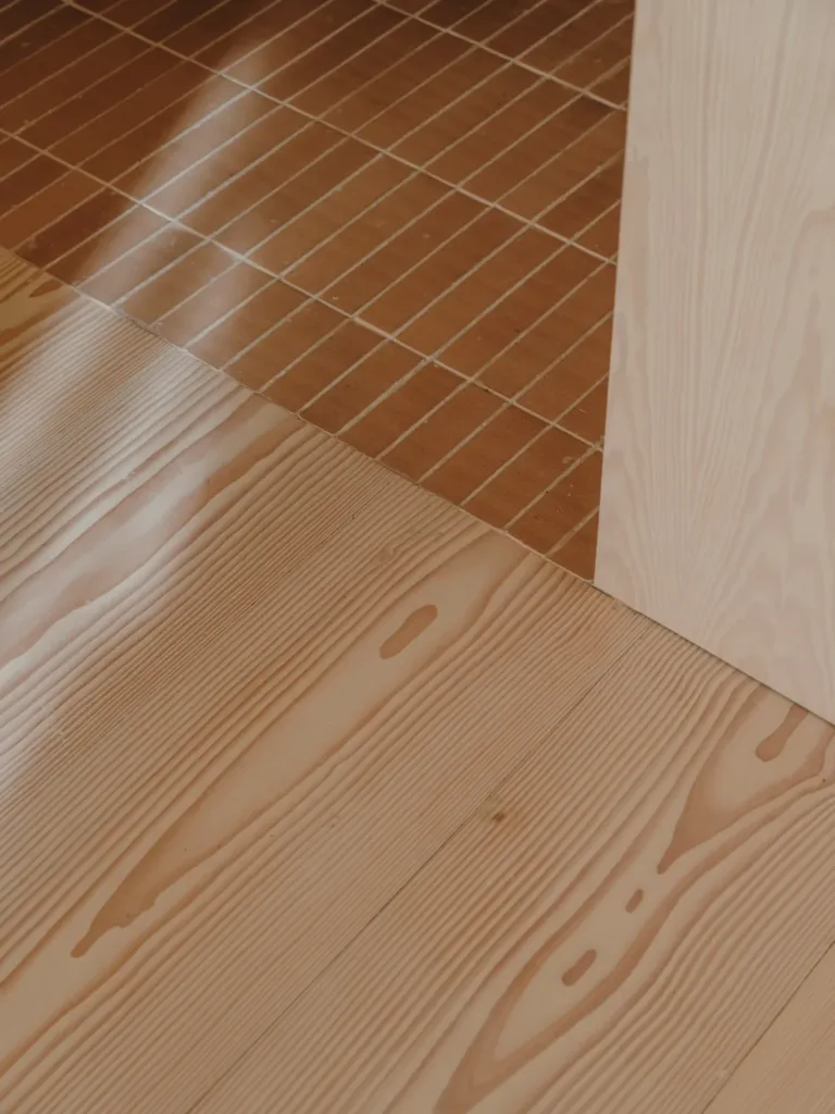 Detalle del encuentro entre el suelo Dinesen Layers Douglas y el pavimento cerámico en Casa Ambrose