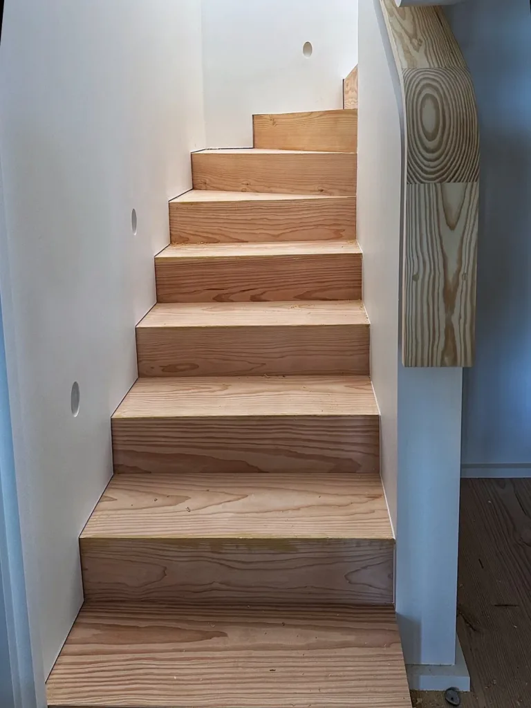 Tramo recto de escalera revestido de madera, con huellas y tabicas de la misma especie