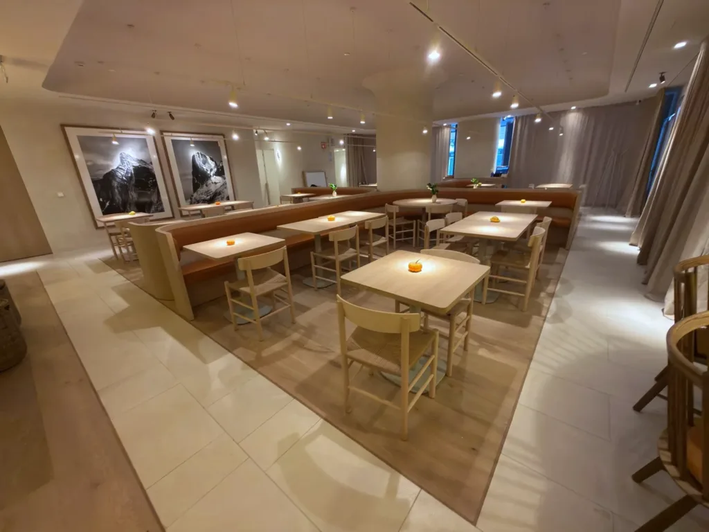 Sala de La Maruca de Azca (Madrid) con suelo Dinesen Oak Natural en anchos combinados, bancada corrida y fotografías de los Picos de Europa