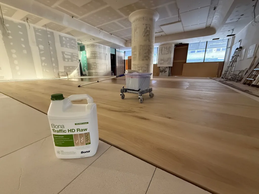 Garrafa de Bona Traffic HD Raw sobre el suelo de roble Dinesen recién barnizado, con la obra en curso