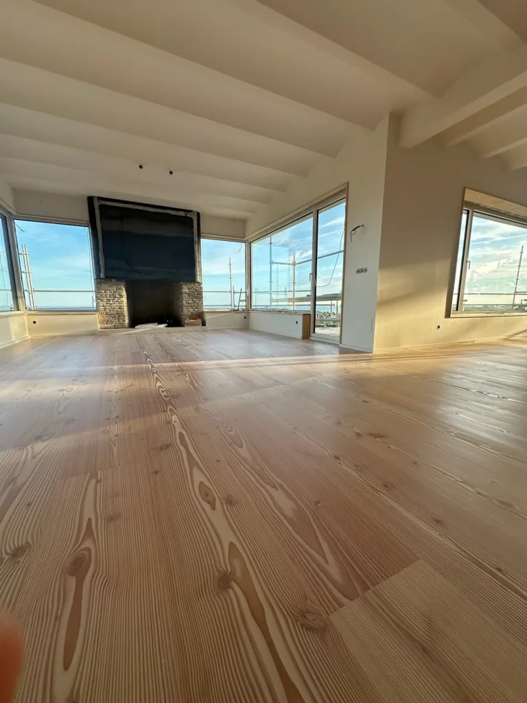 Salón a contraluz con chimenea y ventanales, tablas Dinesen Douglas Natural de 28 × 350 mm, La Modernita, Ruiloba (Cantabria)