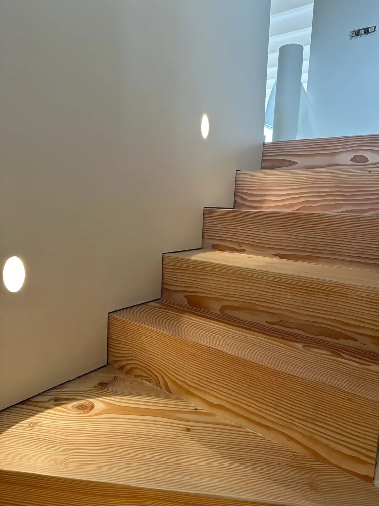 Tramo recto de la escalera con peldaños enterizos de Dinesen Douglas de 35 × 450 mm y luces empotradas, La Modernita, Ruiloba (Cantabria)