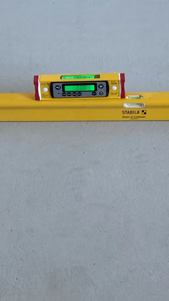Nivel digital Stabila marcando 0,00 sobre la solera de cemento antes de la instalación