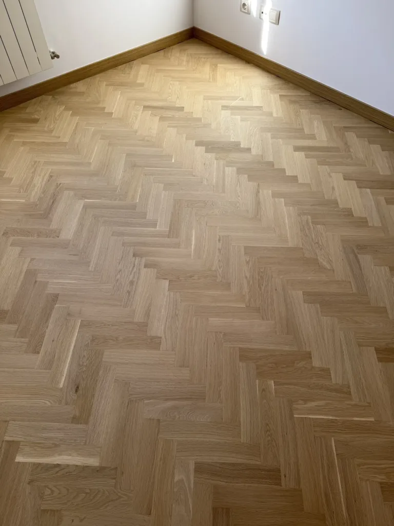 Detalle del parquet de roble en espiga con acabado ultramate Bona Traffic HD Raw, junto al rincón del radiador, piso con mirador en Madrid