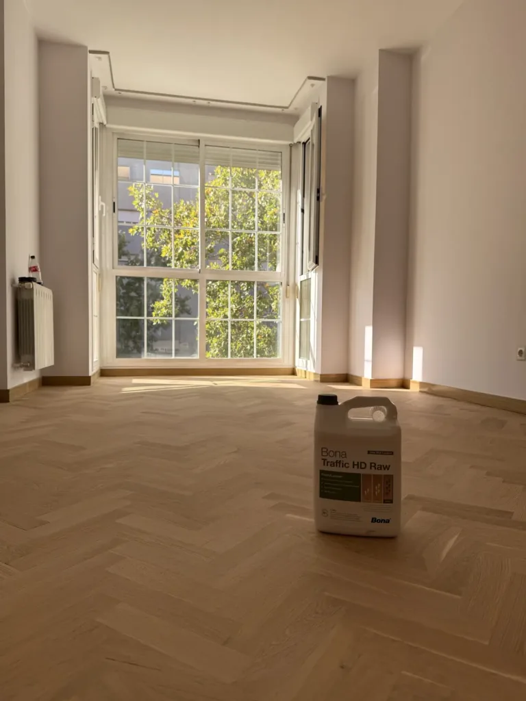 Habitación con mirador y parquet de roble en espiga terminado con Bona Traffic HD Raw, con el envase del barniz en el suelo, piso con mirador en Madrid