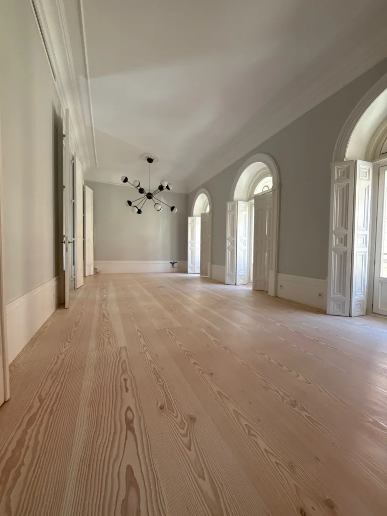 Salón con tres balcones de arco y lámpara de brazos, suelo Dinesen Douglas Classic de 350 mm restaurado con aceite Bona Craft Oil 2K Frost, vivienda en el barrio de Palacio (Madrid)