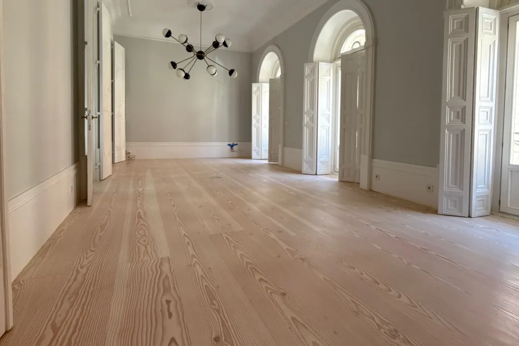 Salón con balcones de arco y suelo Dinesen Douglas Classic restaurado con Bona Craft Oil 2K Frost, vivienda en el barrio de Palacio (Madrid)