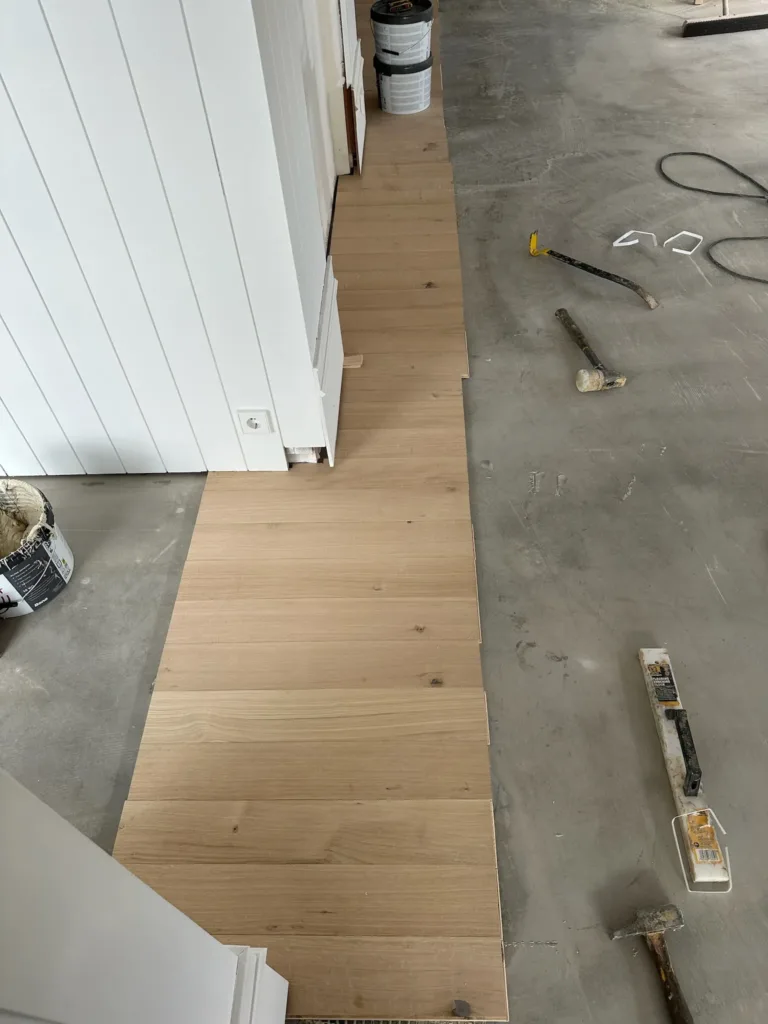 Primeras hileras de tablas de roble multicapa encoladas a lo largo de la pared del restaurante