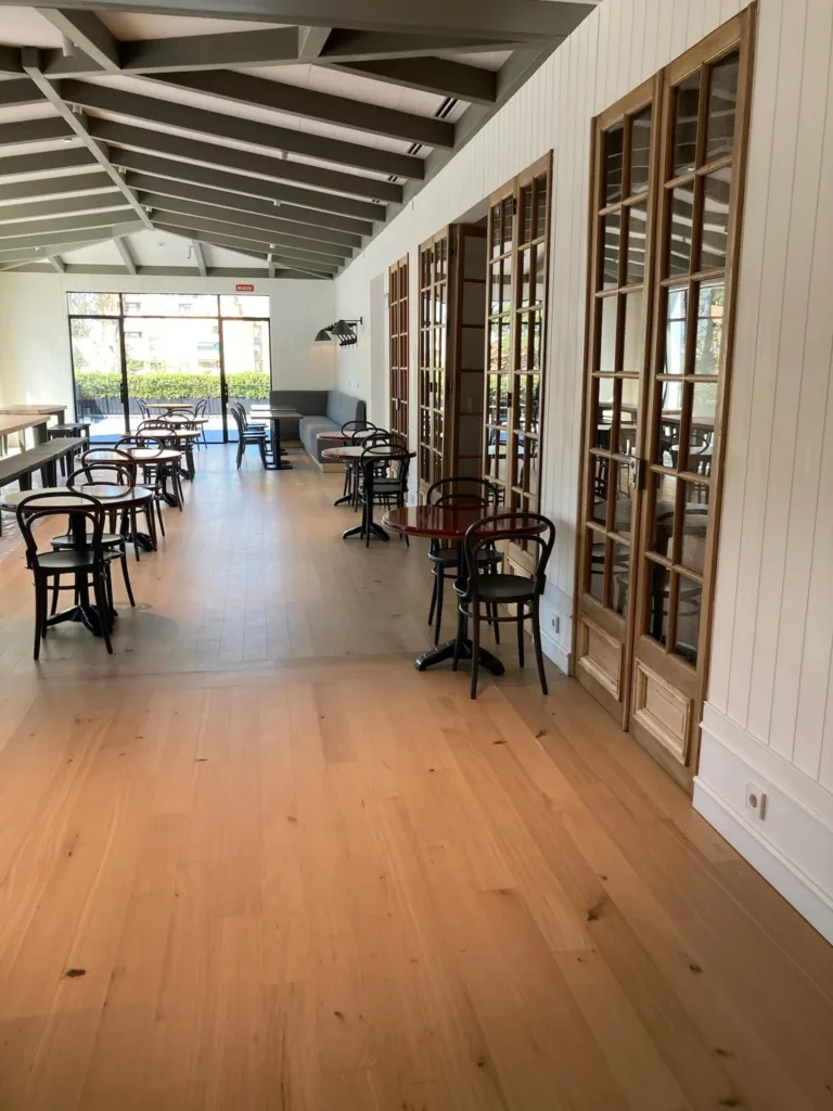 Restaurante del Campus Acciona con el suelo de roble multicapa terminado con Bona Traffic HD Raw y una banda de tablas en el paso entre salas