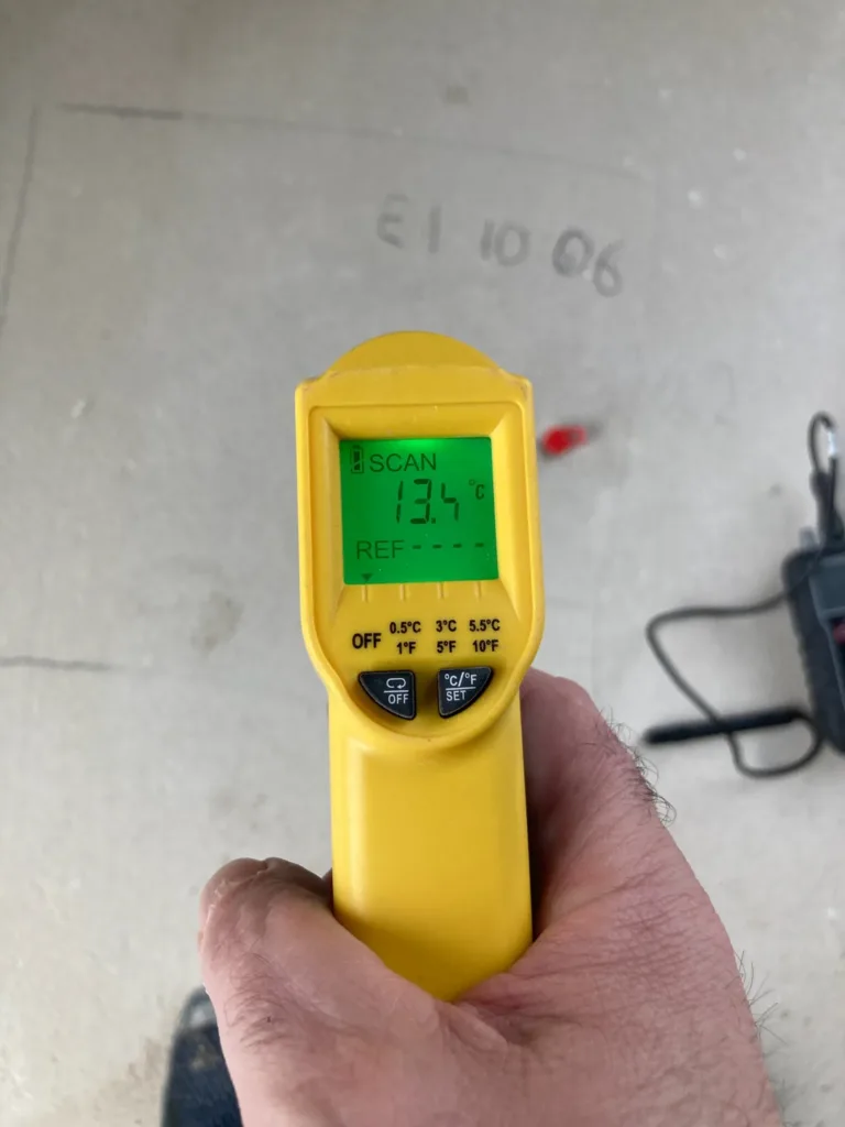 Termómetro de infrarrojos con 13,4 °C en la superficie de la solera, junto al punto de ensayo E1