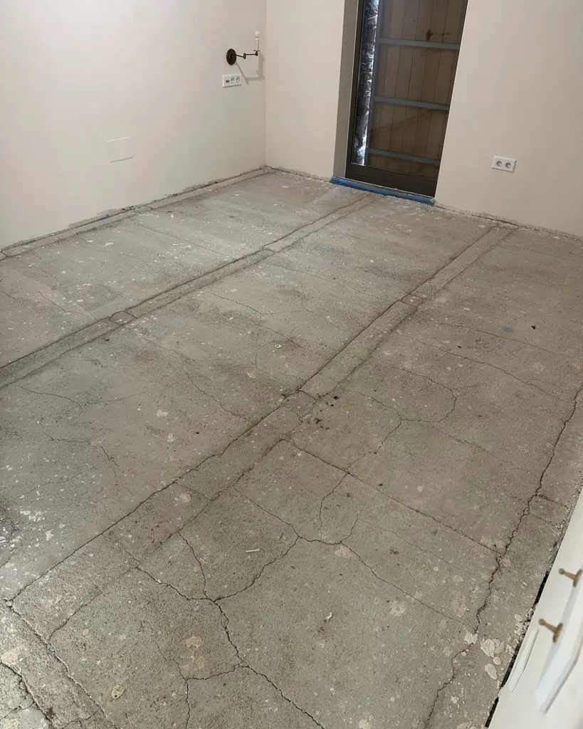 Solera de mortero con fisuras de retracción en toda la superficie y regatas de instalaciones, antes de decidir si se acepta como soporte
