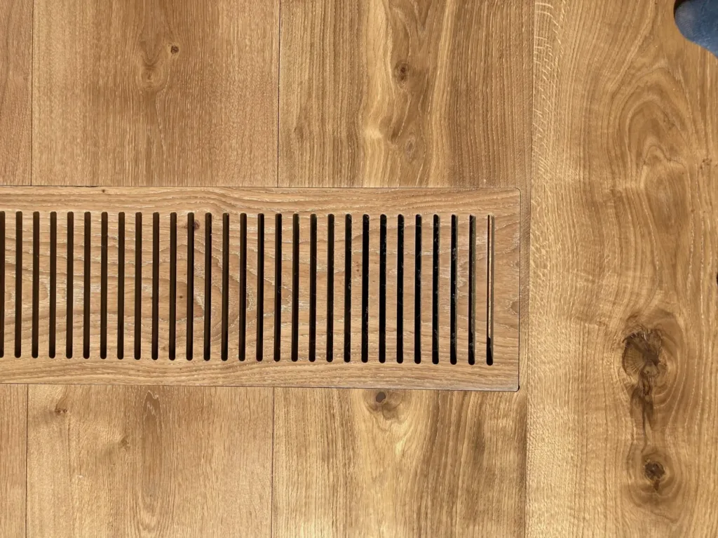 Detalle de la rejilla de clima ranurada en CNC, encajada a ras en las tablas Dinesen HeartOak