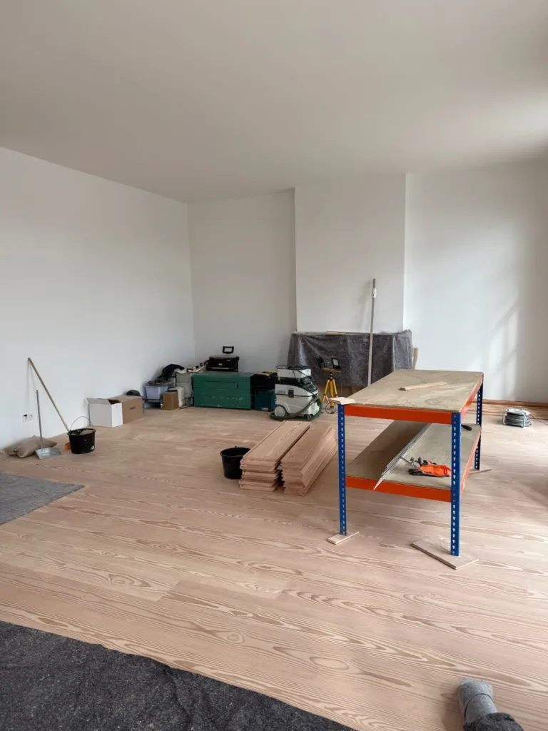 Salón durante la instalación del suelo Dinesen Layers Douglas, con el banco de corte y el aspirador