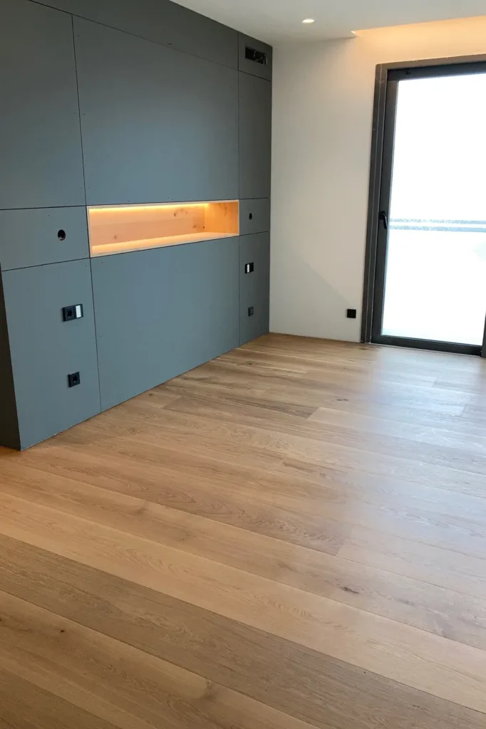 Dormitorio al terminar la instalación, con panel gris y hornacina iluminada, suelo Dinesen Oak Classic de 250 mm, vivienda en la Costa Blanca