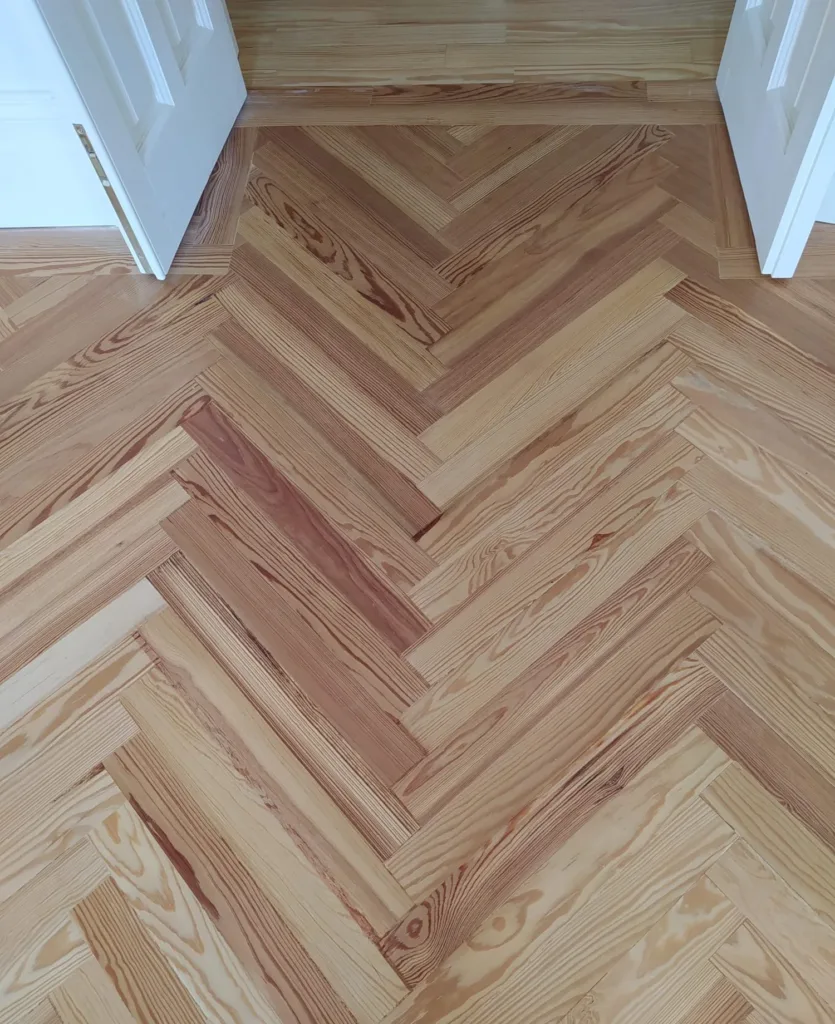 Detalle de la espiga de pino melis viejo con la cenefa de tablas rectas en un paso de puerta de dos hojas, vivienda en la calle Francisco de Rojas (Madrid)