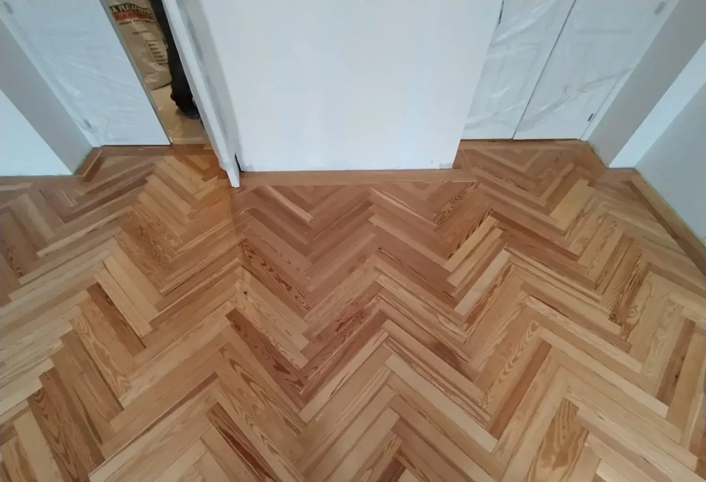 Espiga de pino melis viejo barnizada con la cenefa que recorre los pasos de puerta, vivienda en la calle Francisco de Rojas (Madrid)
