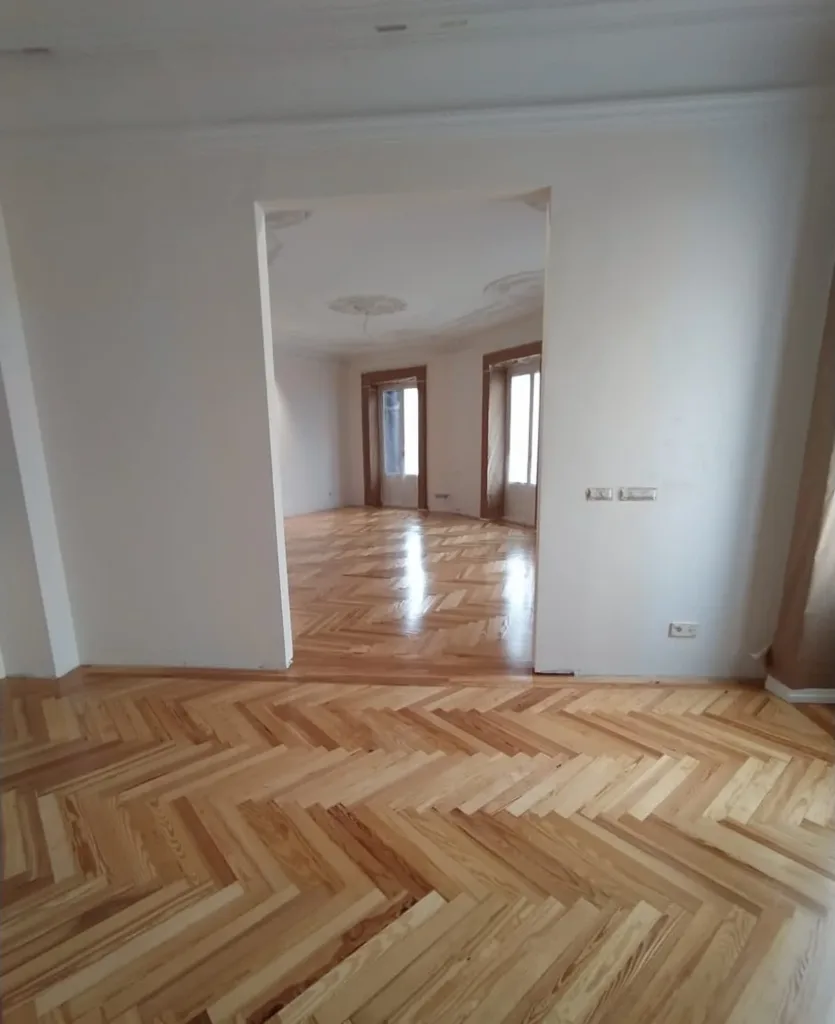 Espiga de pino melis viejo barnizada, con la cenefa de tablas rectas en el paso hacia el salón, vivienda en la calle Francisco de Rojas (Madrid)
