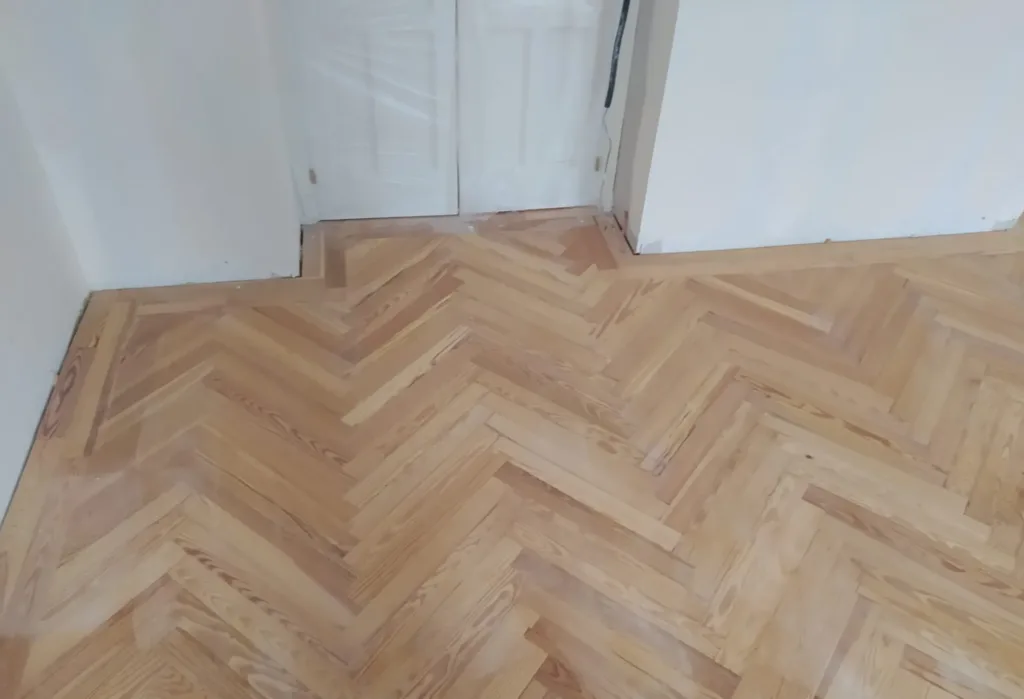 Espiga de pino melis viejo lijada con la cenefa que sigue el paso de la puerta, vivienda en la calle Francisco de Rojas (Madrid)