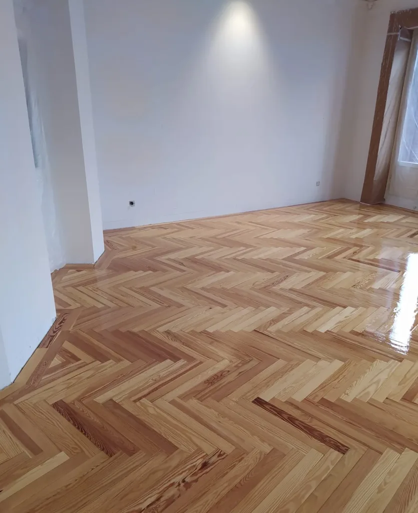 Primera mano de barniz Bona Mega brillo sobre la espiga de pino melis viejo, vivienda en la calle Francisco de Rojas (Madrid)