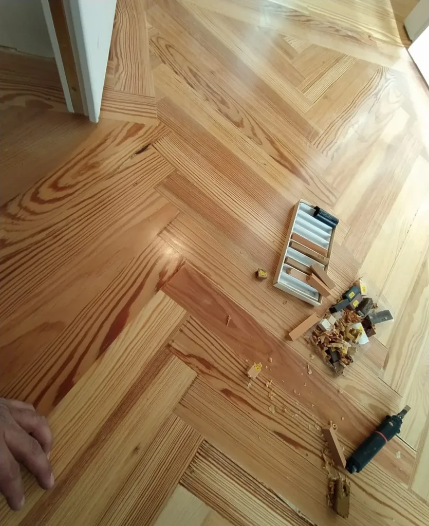 Relleno de pequeñas fendas del pino melis viejo con barras de cera dura en varios tonos, vivienda en la calle Francisco de Rojas (Madrid)