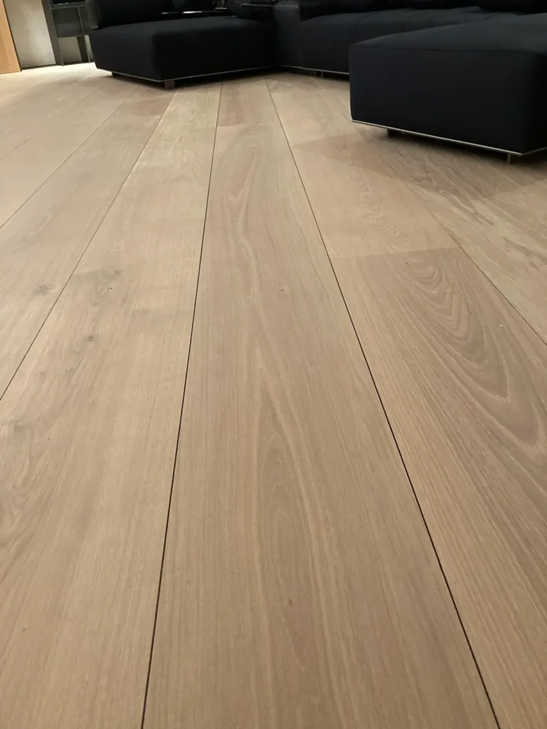 Salón con sofás oscuros sobre suelo Dinesen Oak Classic de 300 mm acabado con aceite Light Oil 2K