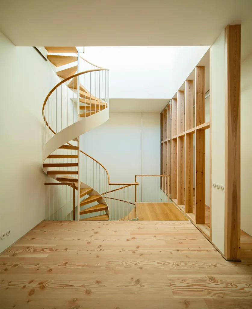 Distribuidor con escalera de caracol y celosía de madera, suelo Dinesen Douglas encolado sobre suelo radiante, vivienda en Las Cárcavas (Madrid)