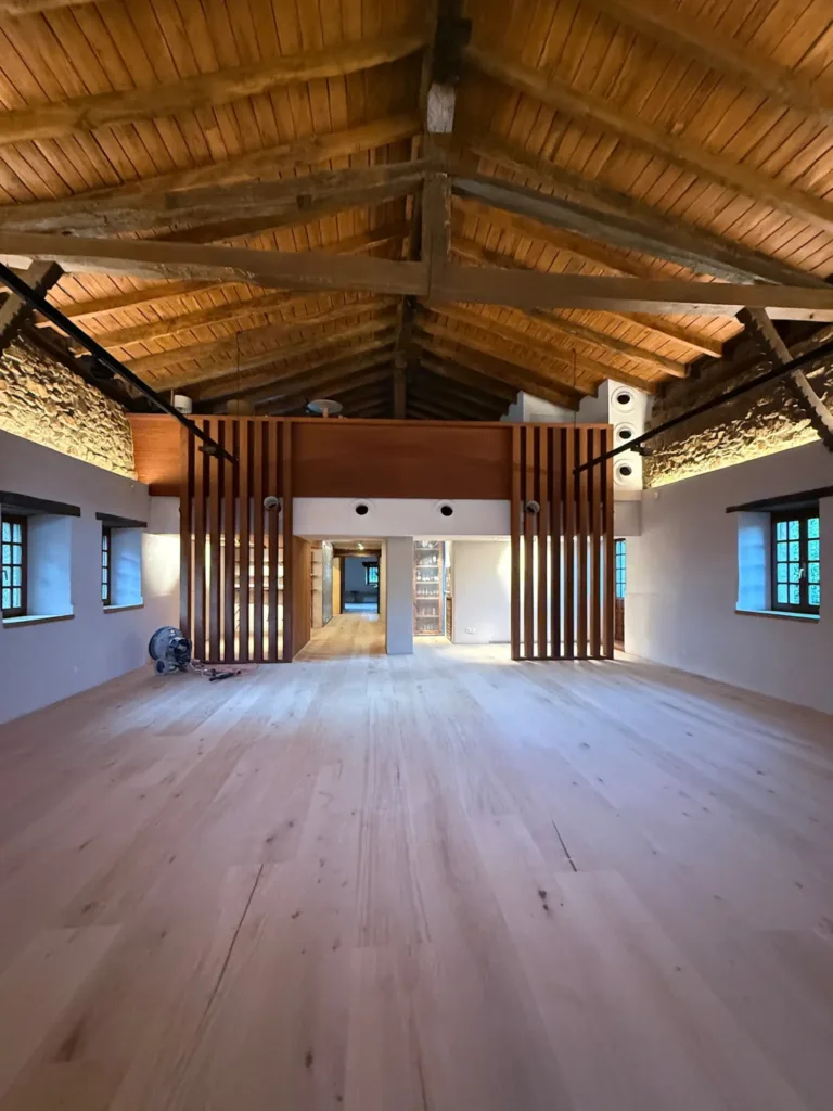 Sala bajo la cubierta de madera del Asador Etxebarri, con suelo Dinesen Layers HeartOak y una celosía de listones al fondo