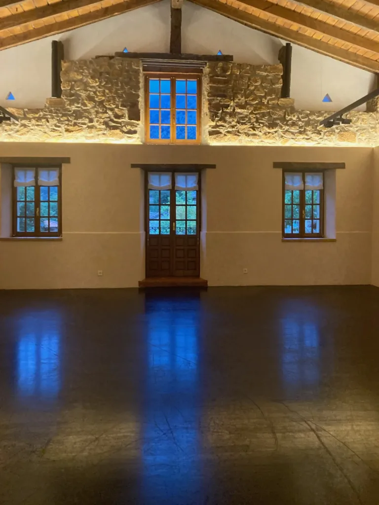 Salón del Asador Etxebarri antes de la obra, con el parquet anterior, oscuro y brillante, bajo la pared de piedra