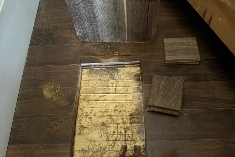 Cata abierta en un parquet encolado levantado, con las tablas retiradas al lado