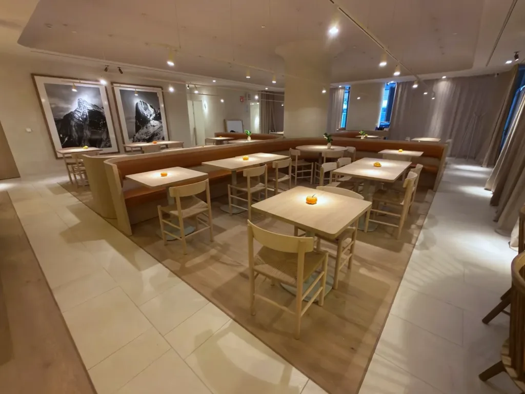 Sala de La Maruca de Azca (Madrid) con suelo de madera Dinesen Oak Natural en anchos combinados, bancada corrida y fotografías de los Picos de Europa