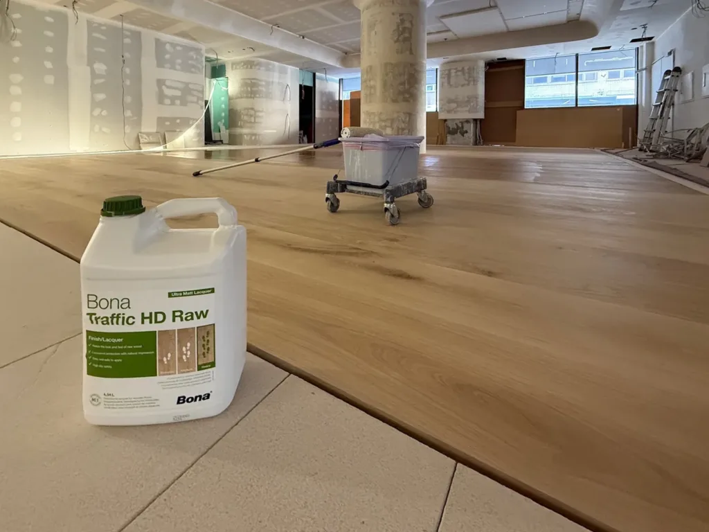 Garrafa de Bona Traffic HD Raw sobre el suelo de roble Dinesen recién barnizado, con la obra en curso