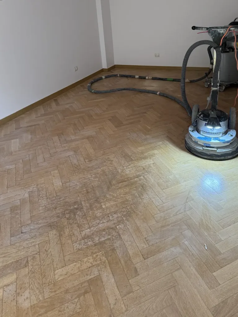 Acuchillado de un parquet de roble en espiga con la lijadora Bona FlexiSand y aspiración por manguera, piso con mirador en Madrid