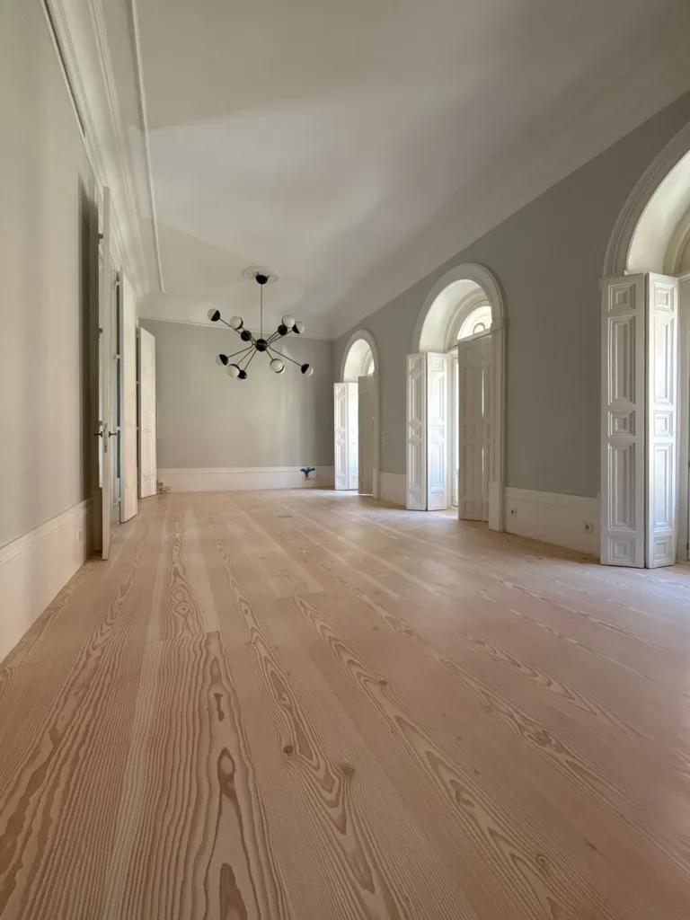 Salón con tres balcones de arco y lámpara de brazos, suelo Dinesen Douglas Classic de 350 mm restaurado con aceite Bona Craft Oil 2K Frost, vivienda en el barrio de Palacio (Madrid)