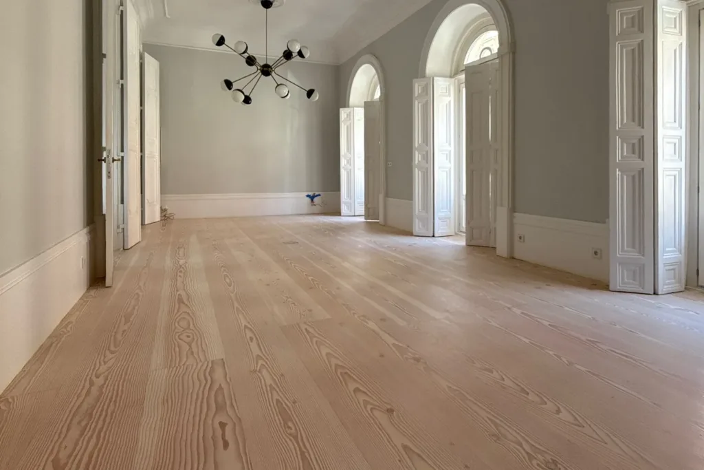 Salón con balcones de arco y suelo de madera Dinesen Douglas Classic restaurado con Bona Craft Oil 2K Frost, vivienda en el barrio de Palacio (Madrid)