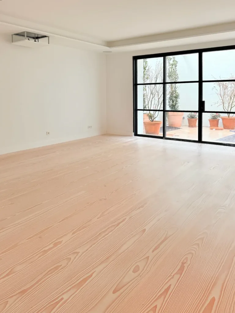 Salón abierto al patio con suelo Dinesen Layers Douglas Classic acabado con lejía y jabón blanco
