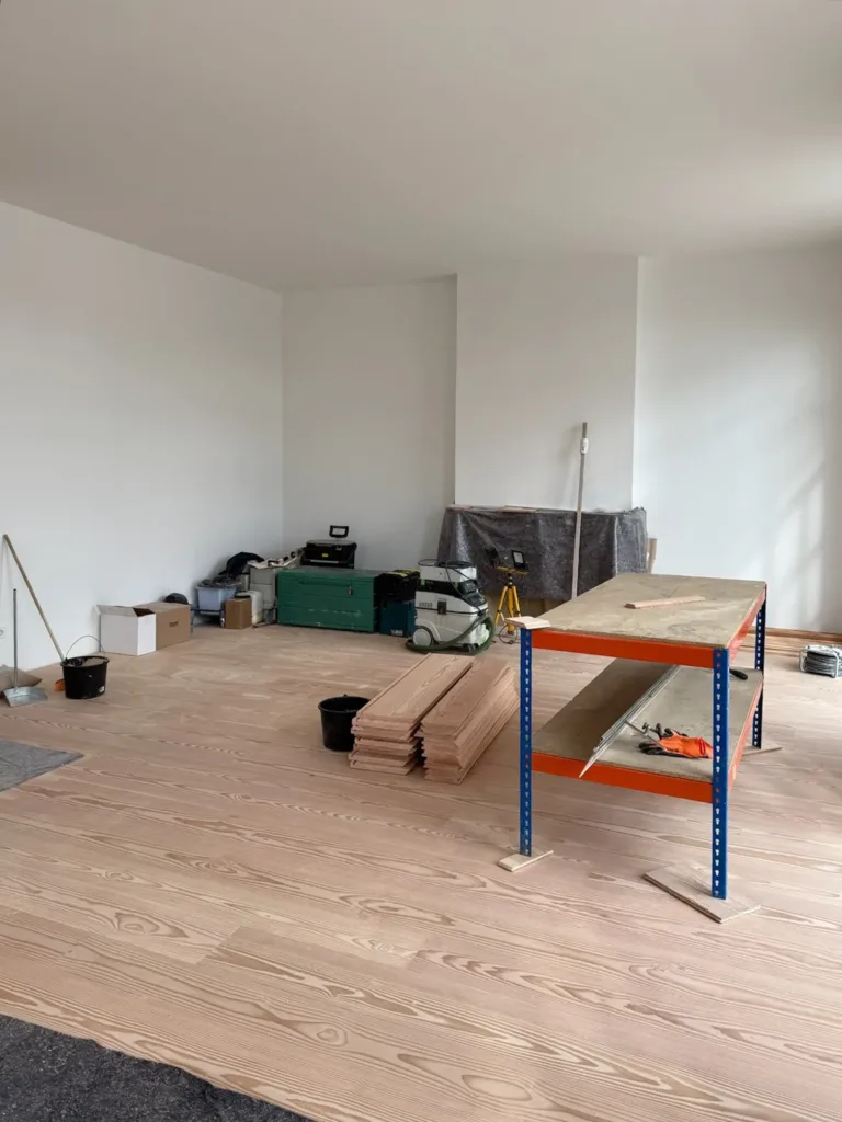 Salón durante la instalación del suelo Dinesen Layers Douglas, con el banco de corte y el aspirador